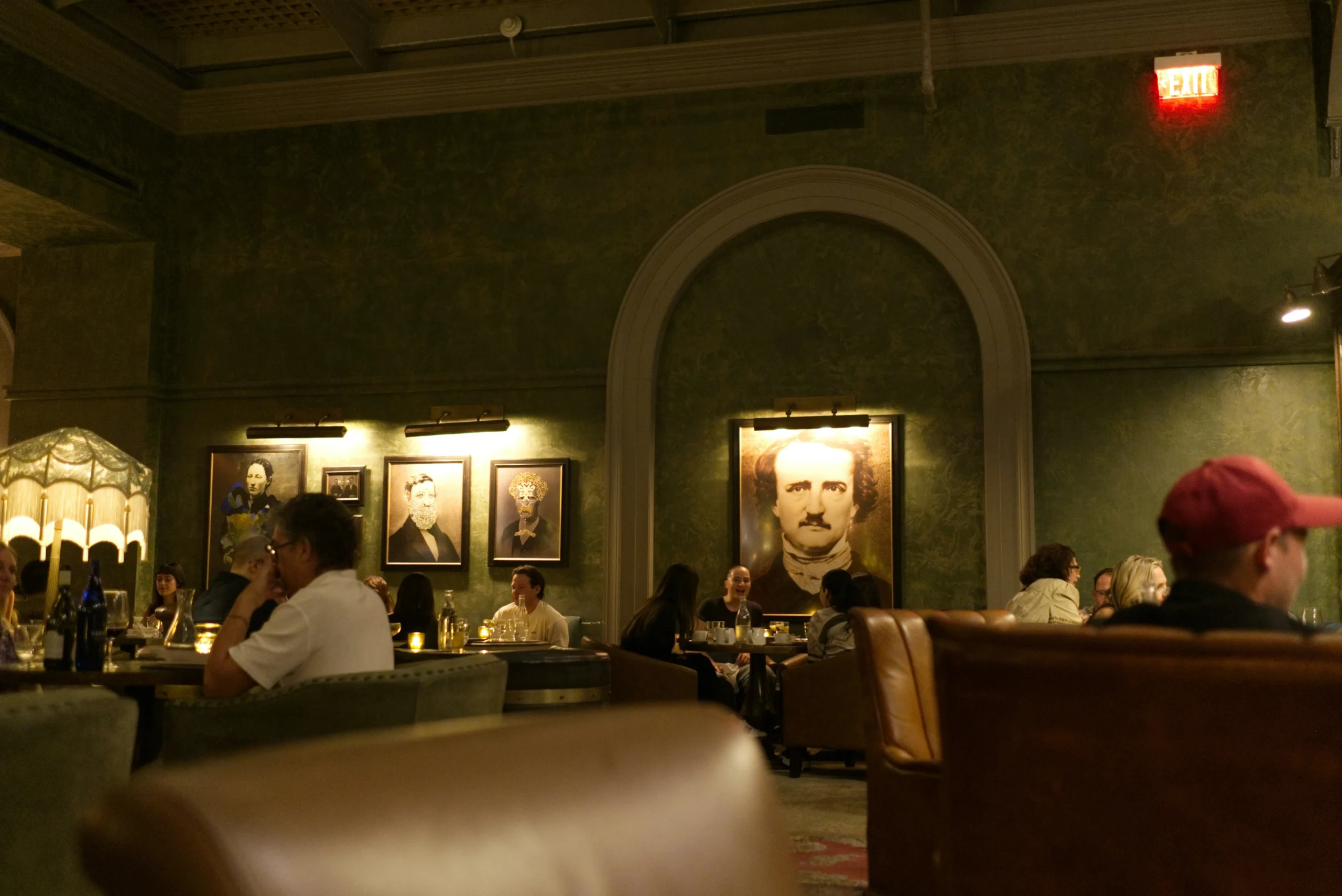 A sophisticated restaurant setting featuring intimate seating arrangements, vintage portraits on the walls, and a warm ambiance, perfect for a memorable dining experience.