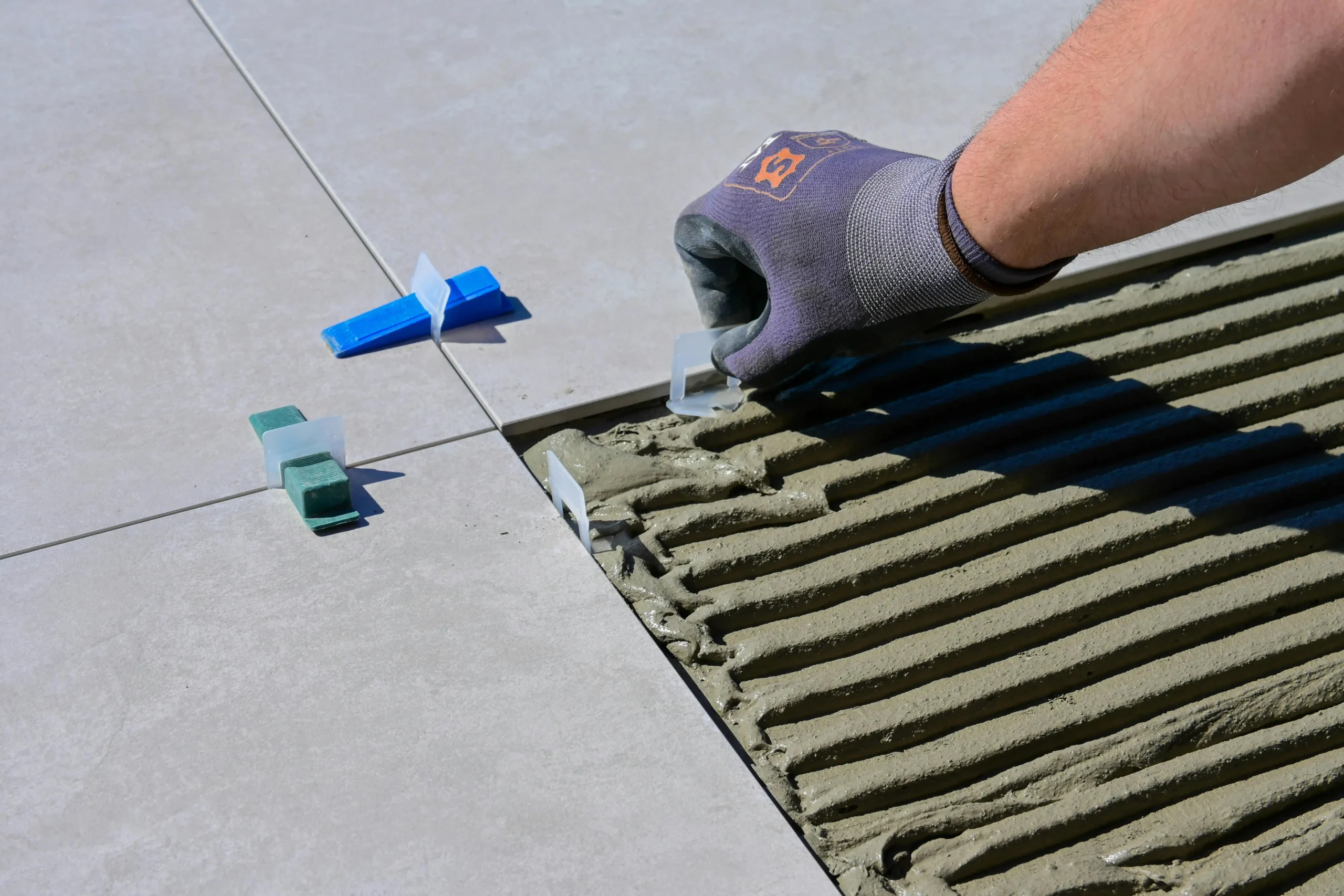 A worker applying adhesive to the floor and laying tiles with accuracy during a restaurant renovation, ensuring a flawless and durable tile installation for a modern dining space.